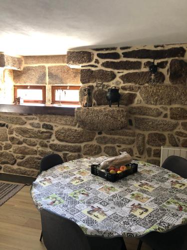 a table in a room with a stone wall at Casa da Tia Balbina - Medeiros in Medeiros