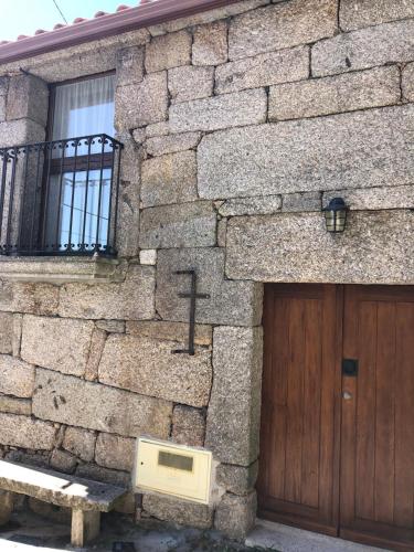 a stone building with a wooden door and a wooden gate at Casa da Tia Balbina - Medeiros in Medeiros