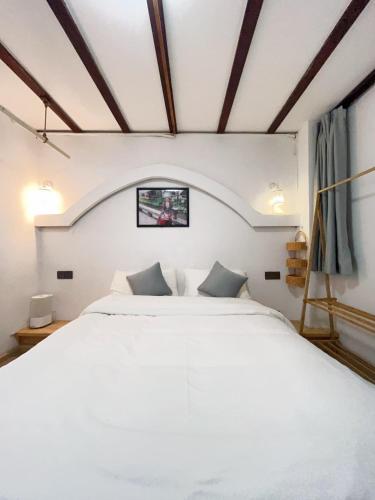 a bedroom with a large white bed with two pillows at Leisure Inn in Lijiang