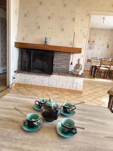 un groupe de tasses à thé sur une table dans un salon dans l'établissement Belle maison 4 chambres pour 8 personnes, au Mans