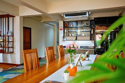 a dining room with a table with a vase of flowers at Art house Old City in Chiang Mai