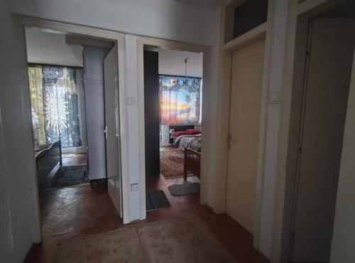 a hallway with a room with a bed and paintings on the walls at Apartment Korzo in Bjelovar