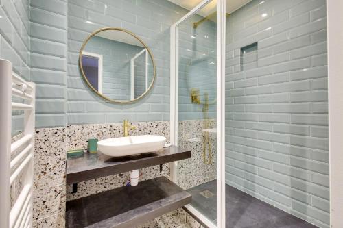 une salle de bain avec un lavabo et un miroir dans l'établissement Bluestay 56 - Superbe appartement à Paris, à Paris