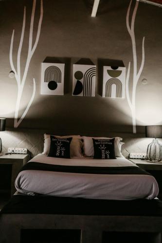 a bedroom with a bed with black and white art on the wall at Overnight Stop Before Kruger National Park in Phalaborwa