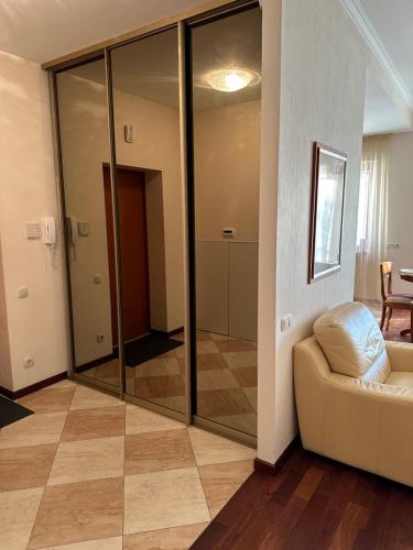 a living room with glass doors and a couch at Jūras pils - Bulduru 33-27 in Jūrmala