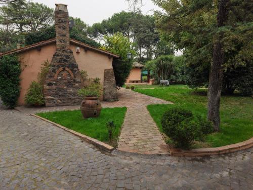 a brick path leading to a house with a brick chimney at Villa Bovari - Appia Antica in Rome