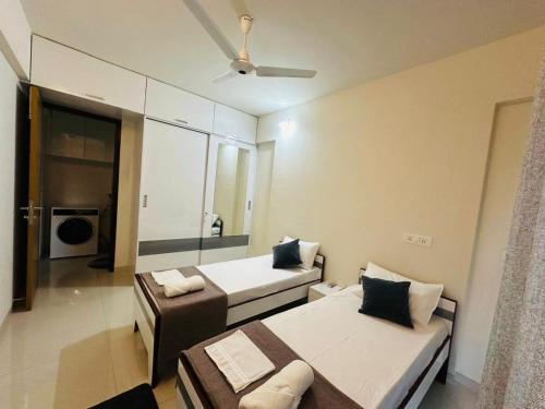 a bedroom with two beds and a ceiling fan at Residential Tranquil in Mumbai