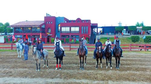 a group of people riding horses in a field at Regal Suite by StayMehman in Rawalpindi