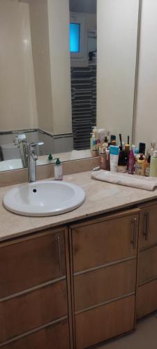 eine Badezimmerablage mit Waschbecken und Spiegel in der Unterkunft Les perles de Tamaris in Dar Mohammed Ould Haj Jilali