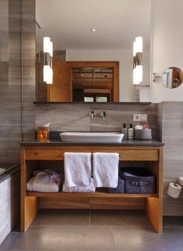 a bathroom with a sink and a counter with towels at Valluga Hotel in Sankt Anton am Arlberg
