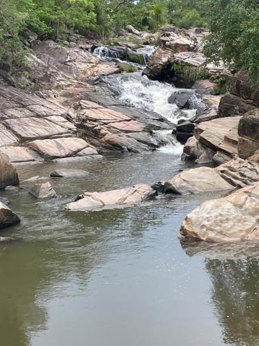 a stream of water with rocks and a waterfall at Céu da Terra in Colinas Do Sul
