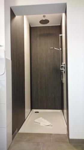 a bathroom with a shower with a towel on the floor at Gästehaus Langhammer in Bubenreuth