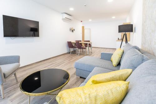 a living room with a blue couch and a tv at NEKA Village in Balatonboglár