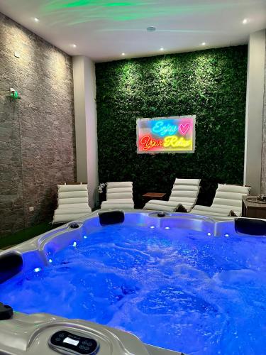 a large blue hot tub in a room with chairs at Sicily in Love - Rooms & Breakfast in Taormina