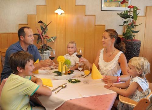 a family sitting at a table with wine glasses at Retzerlandhof Familie Graf in Zellerndorf