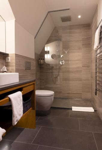 a bathroom with a shower and a toilet and a sink at Valluga Hotel in Sankt Anton am Arlberg