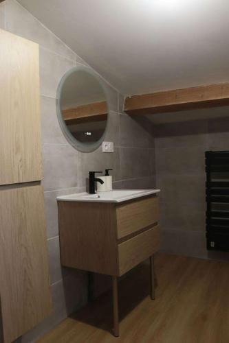 une salle de bain avec un lavabo et un miroir dans l'établissement Maison medocaine familiale, à Saint-Sauveur