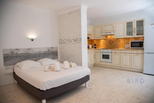 une chambre avec un grand lit et une cuisine dans l'établissement Spacious studio 4 minutes walk from the Beaches, à Cannes