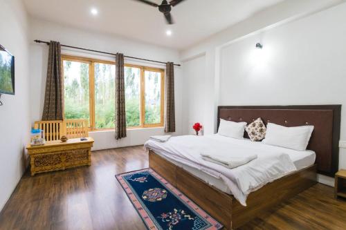 a bedroom with a large bed and a large window at Leh Stumpa in Leh