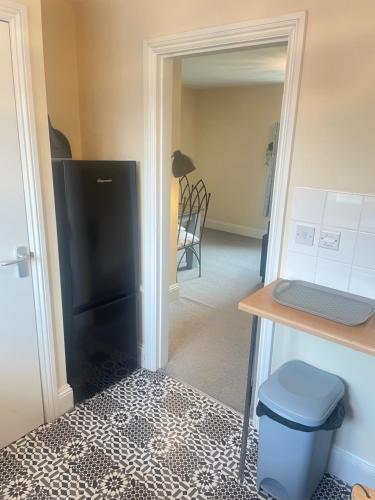 a kitchen with a black refrigerator and a table at Hamilton heights in Ellesmere