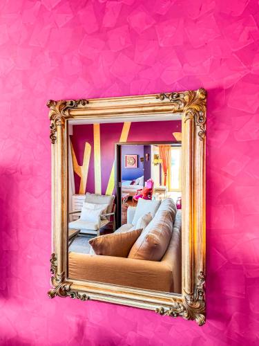 a mirror on a pink wall with a couch at Boutique Hotel Vivenda Miranda in Lagos