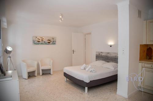 - une chambre avec un lit et deux chaises dans l'établissement Spacious studio 4 minutes walk from the Beaches, à Cannes