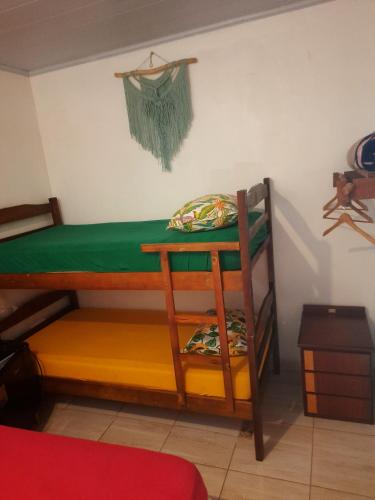a bunk bed in a room with a green sheet at Hospedagem Jabuti no Centro de São Jorge in Sao Jorge
