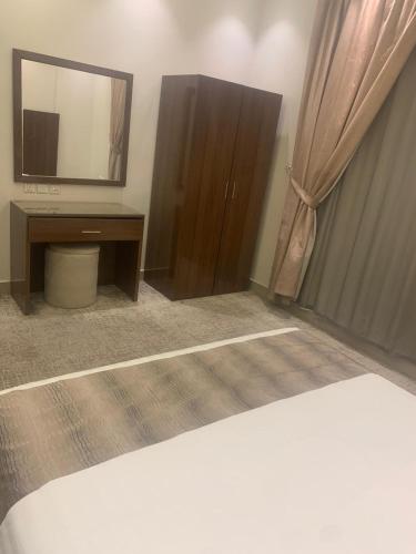 a bedroom with a bed and a dresser and a mirror at هذه ليلتي- اليرموك- طريق الدمام This Lailaty Al Yarmouk-Dammam Road in Riyadh