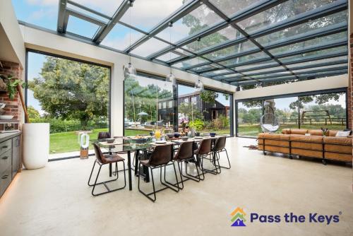 a conservatory with a glass ceiling and a table and chairs at Country House, 4 Acres, Views & Swimming Pool in Stockcross