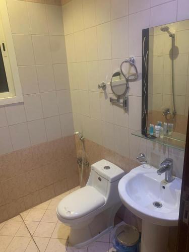 a bathroom with a toilet and a sink at هذه ليلتي- اليرموك- طريق الدمام This Lailaty Al Yarmouk-Dammam Road in Riyadh