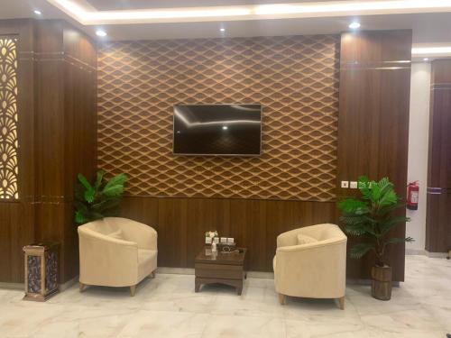 a lobby with two chairs and a tv on a wall at هذه ليلتي- اليرموك- طريق الدمام This Lailaty Al Yarmouk-Dammam Road in Riyadh