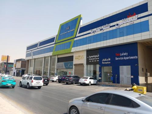 a parking lot with cars parked in front of a building at هذه ليلتي- اليرموك- طريق الدمام This Lailaty Al Yarmouk-Dammam Road in Riyadh