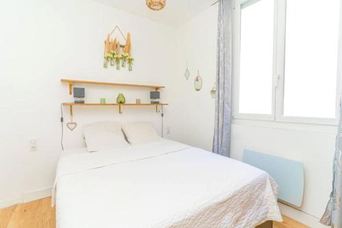une chambre blanche avec un lit et une fenêtre dans l'établissement Entre Terre & Mer Chez Milann, à Marseille