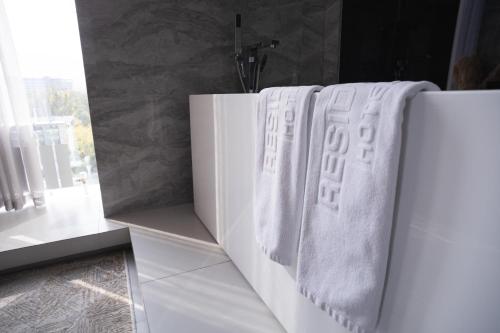 two towels hanging on a wall in a bathroom at Resident City Hotel in Almaty