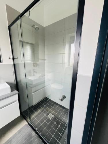 a bathroom with a shower with a glass door at Comfort in the Heart of Waterfall in Kyalami