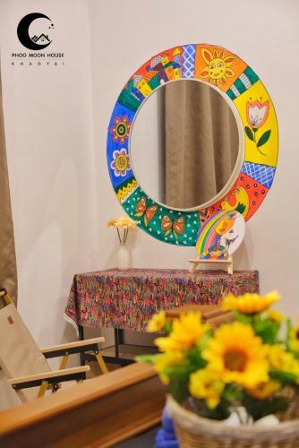 a mirror and a table with a vase of flowers at Phoo Moon House Khao Yai บ้านพัก ภู มูน เขาใหญ่ in Ban Bung Toei