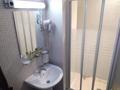 a bathroom with a sink and a shower and a mirror at RentRooms Thessaloniki in Thessaloniki