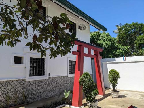 a red chair in front of a white house at 102 Casa de Rany in Dumaguete