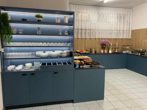 a kitchen with a blue counter with food on it at Hotel Ferrari in Rio do Sul