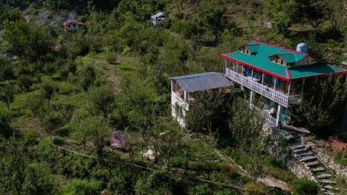 a building with a green roof on a hill at SaffronStays Fairytale Villa - 3 bedroom villa in orchards and access to the river in Gushaini