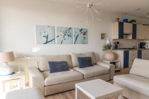 ein Wohnzimmer mit Sofa und Tisch in der Unterkunft Duinerei appartement C102 in Callantsoog