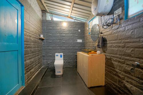 a bathroom with a toilet in a room at SaffronStays Fairytale Villa - 3 bedroom villa in orchards and access to the river in Gushaini