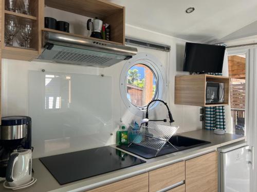 a small kitchen with a sink and a window at Camping-Village del Sole in Cannobio