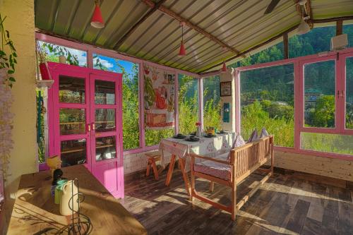 a room with a table and some windows at SaffronStays Fairytale Villa - 3 bedroom villa in orchards and access to the river in Gushaini