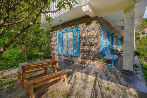 a brick house with a bench on a patio at SaffronStays Fairytale Villa - 3 bedroom villa in orchards and access to the river in Gushaini