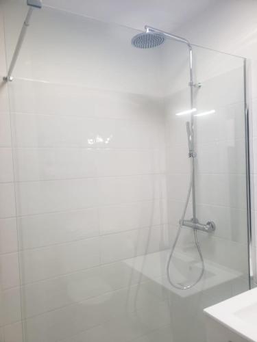 une douche avec une porte vitrée dans une salle de bain dans l'établissement Maison Souquet, à Lamalou-les-Bains