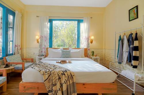 a bedroom with a large bed and a window at SaffronStays Fairytale Villa - 3 bedroom villa in orchards and access to the river in Gushaini