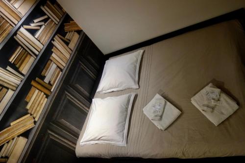 - un lit avec des draps et des oreillers blancs dans l'établissement Charming apartment for 4 people 1 baby in the heart of Paris, à Paris