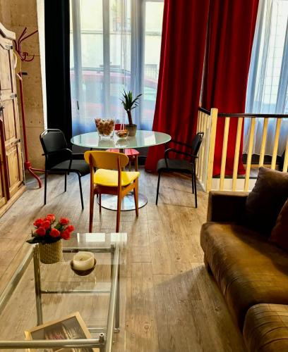 un salon avec un canapé, une table et des chaises dans l'établissement Charming apartment for 4 people 1 baby in the heart of Paris, à Paris
