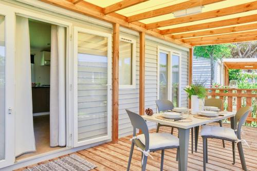 a screened in porch with a table and chairs at ISA-Village with swimming-pool in Montalto Marina just 100 meters from the beach, mobile homes with air conditioning and private outdoor area in Torre di Montalto
